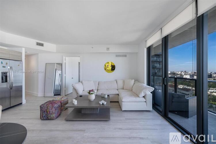 A modern living room with a glass table and a view of the city.