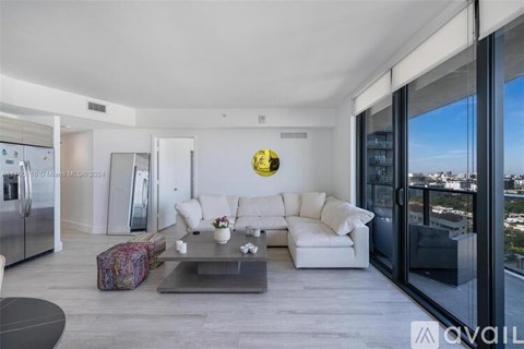 A modern living room with a glass table and a view of the city.