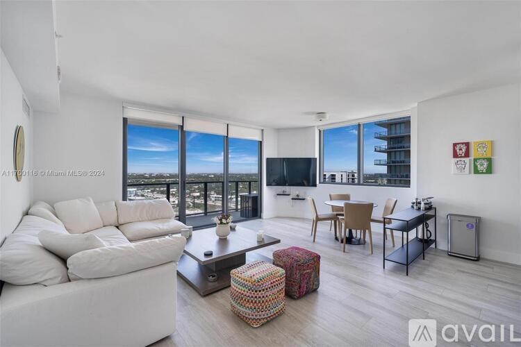 A living room with a large window overlooking the city.