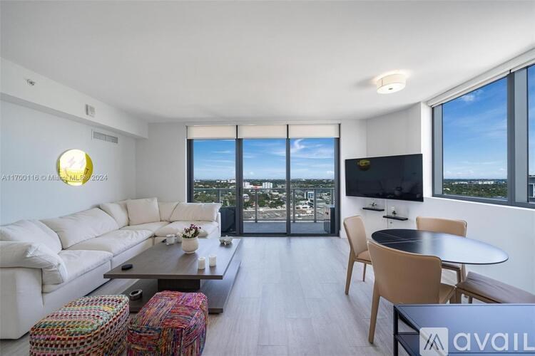 A living room with a white sofa, a coffee table, and a television.