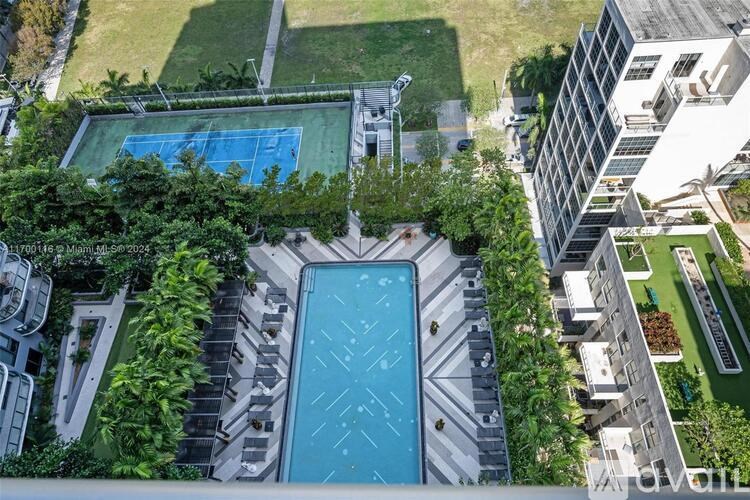 A swimming pool surrounded by trees and buildings.