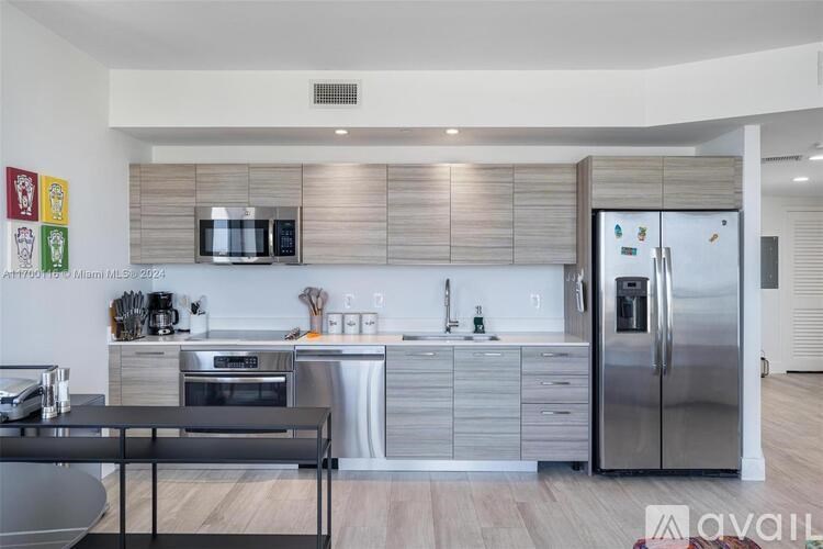 A modern kitchen with stainless steel appliances and wooden accents.
