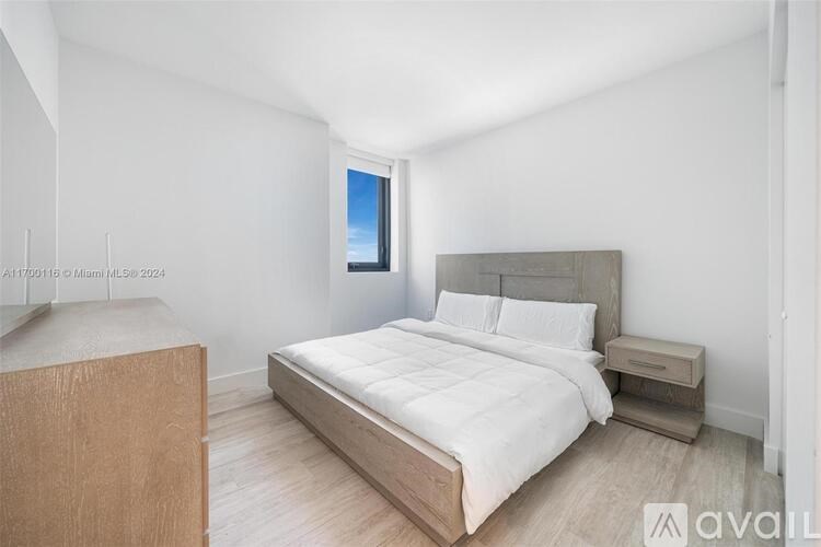 A bedroom with a large bed and a wooden headboard.