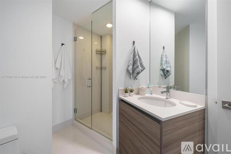 A bathroom with a sink, mirror, and towel rack.