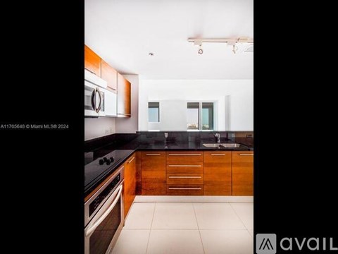 A modern kitchen with wooden cabinets and black countertops.