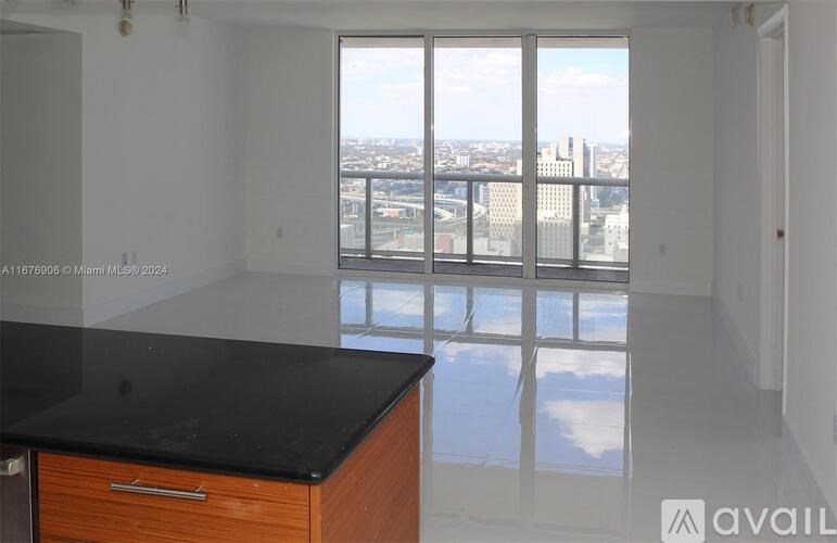 A large empty room with a view of the city through the windows.