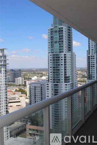 A view from a balcony overlooking a cityscape with tall buildings.