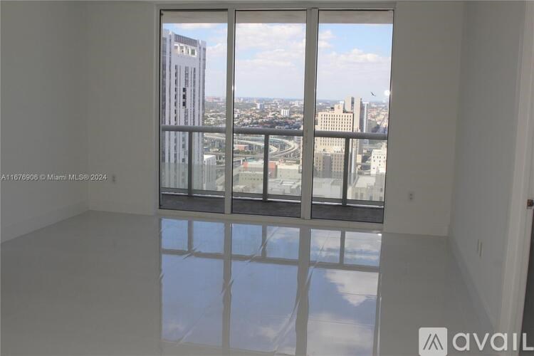 A room with a large window overlooking a cityscape.