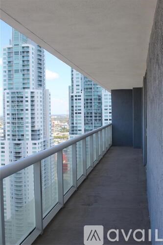 A balcony with glass railings overlooks a cityscape.