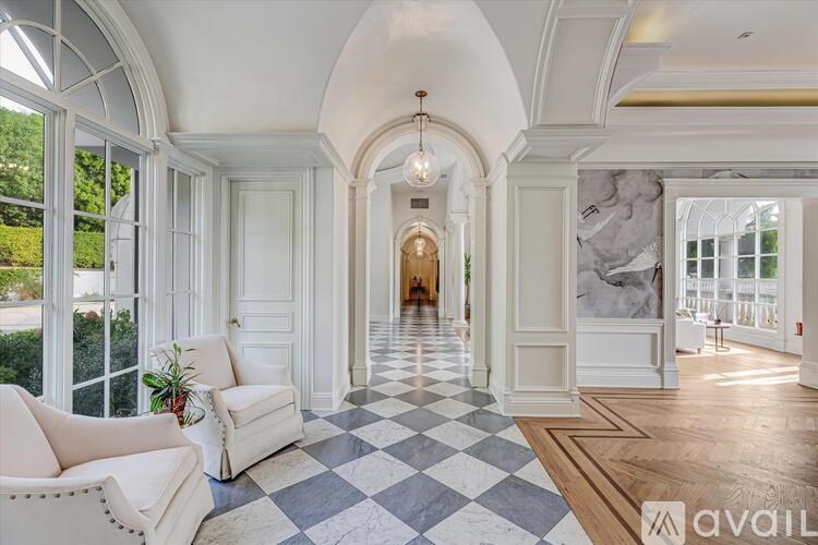 A spacious room with a checkered floor and a long hallway.