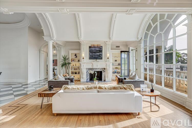A living room with a white couch and a fireplace.