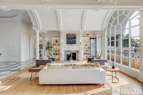 A living room with a white couch and a fireplace.