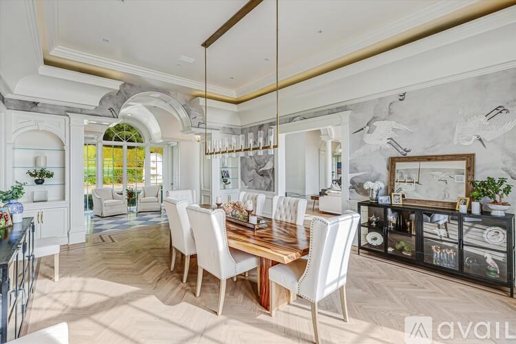 A dining room with a wooden table and white chairs.