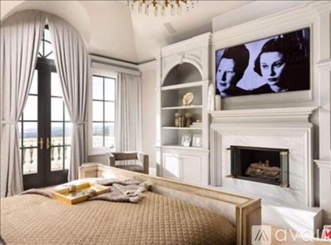 A bedroom with a large bed and a fireplace.