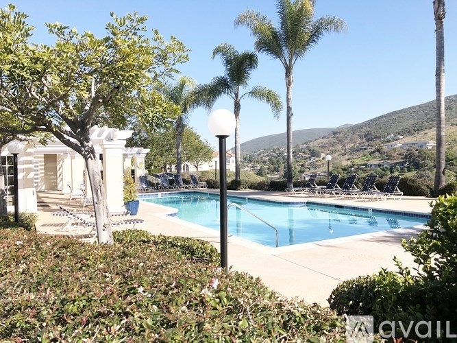 A pool surrounded by palm trees and bushes.