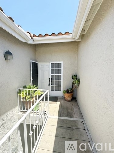 A balcony with a white railing and a door with a window.