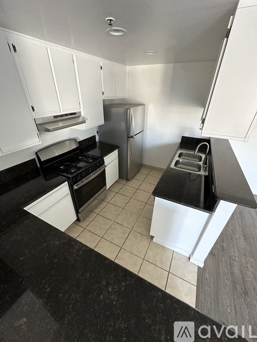 A kitchen with black countertops and white cabinets.