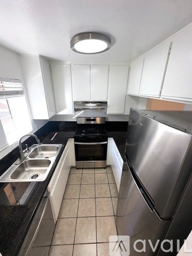 A kitchen with black countertops and white cabinets.