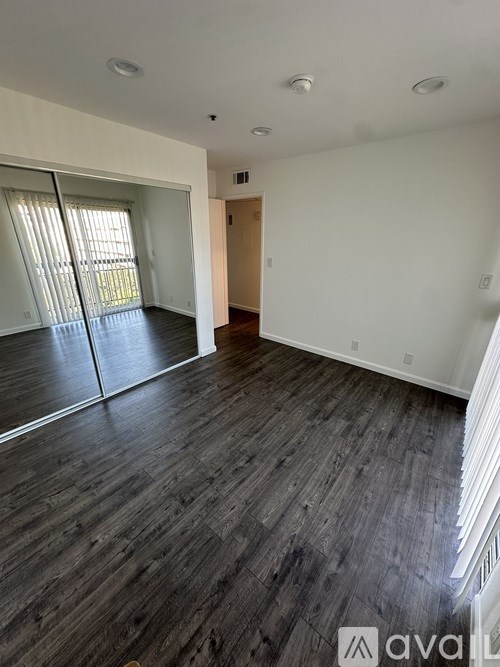 A room with wooden flooring and a sliding glass door.