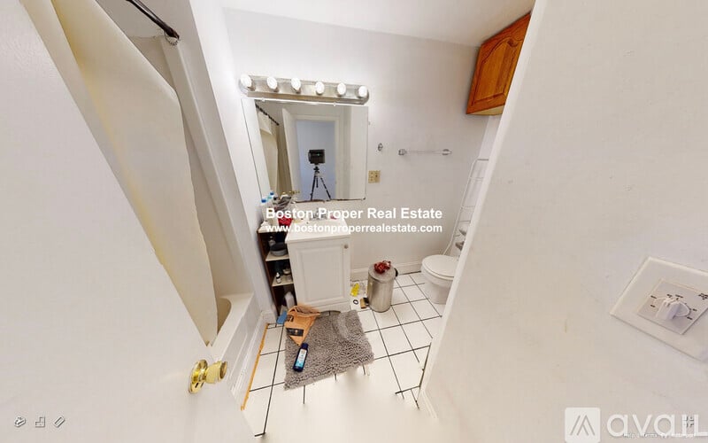 A bathroom with a toilet, sink, and mirror.