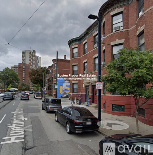 A street view of a residential area with cars parked on the side of the road.