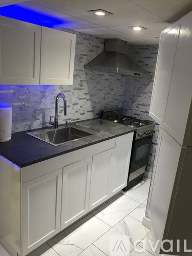 A kitchen with white cabinets and a black countertop.