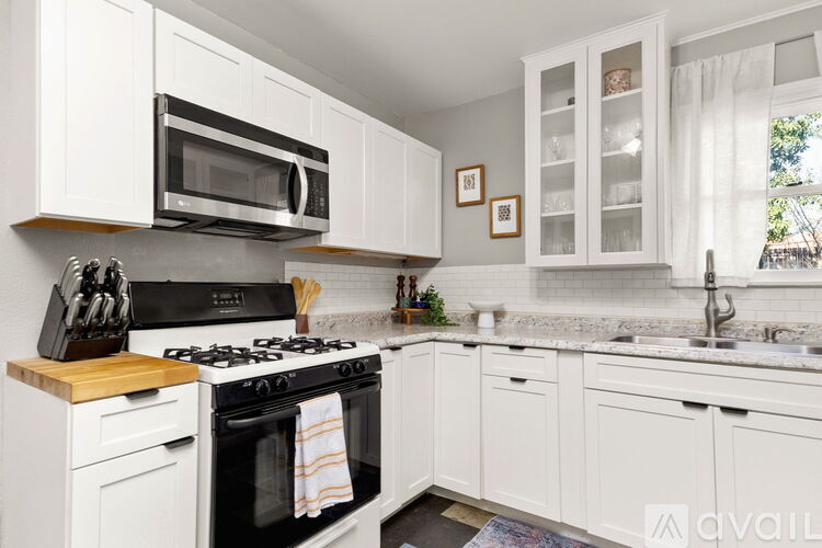 A kitchen with white cabinets and a black stove top.