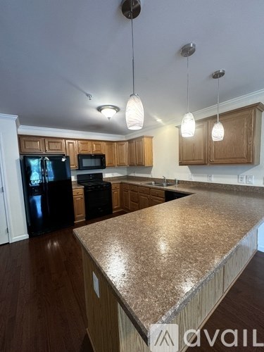A kitchen with wooden cabinets and granite countertops.