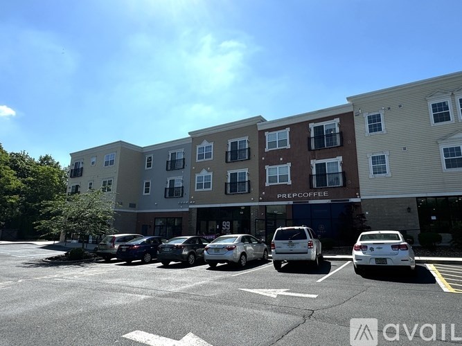 A parking lot with cars and a building with a PreCoffee in front.