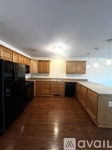 A kitchen with wooden cabinets and black appliances.