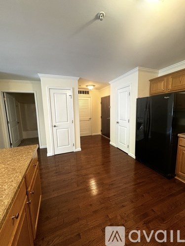 A kitchen with wooden floors and white walls.