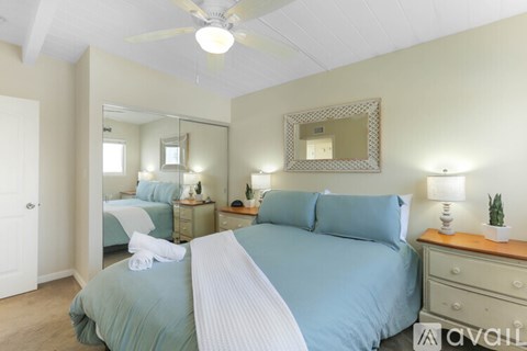 A bedroom with a large bed and a mirror on the wall.