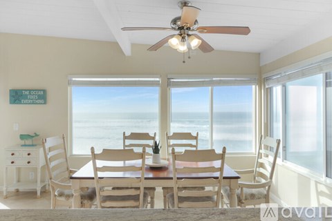A dining room with a view of the ocean.