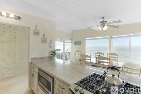 A kitchen with a stove top oven and a fan.