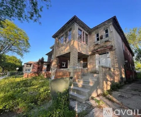 A large, old, two-story house with a lot of windows and a front porch.