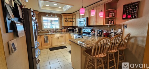 A kitchen with wooden chairs and a granite counter top.