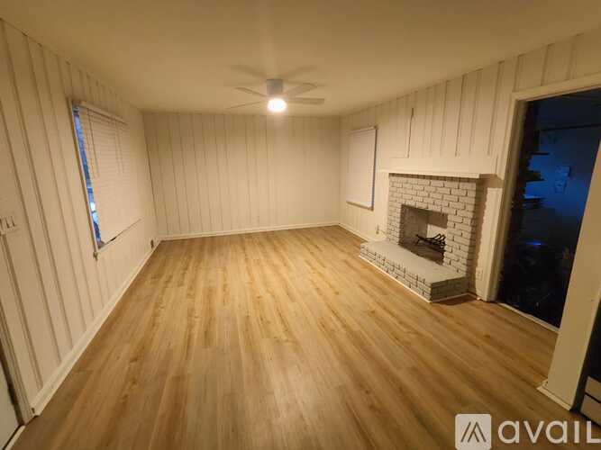 A room with wooden floors and a fireplace.