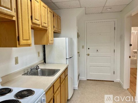 A kitchen with wooden cabinets and a white refrigerator.