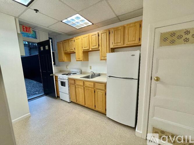 A kitchen with a white refrigerator, white stove, and white sink.