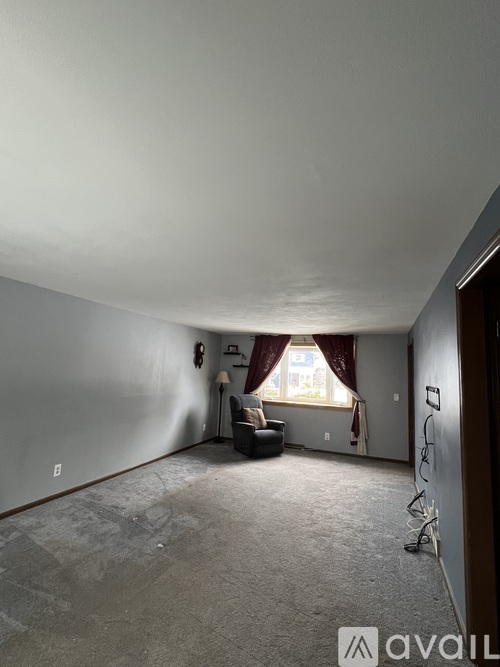 A room with a window and a couch in it.