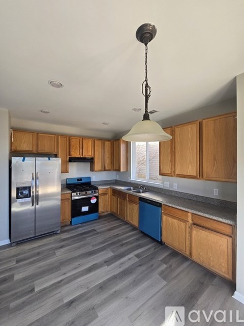 A kitchen with wooden cabinets and a blue dishwasher.