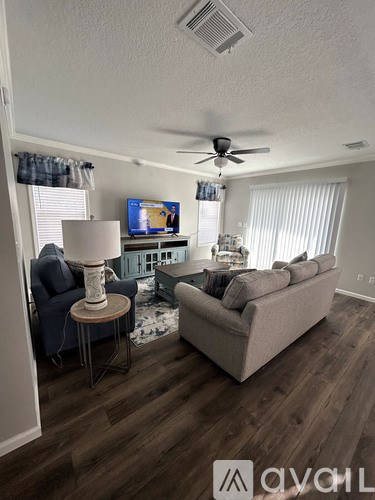 A living room with a couch, chair, and television.