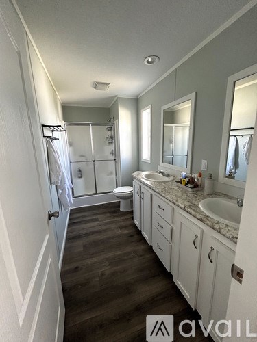 A bathroom with a walk-in shower, toilet, and sink.