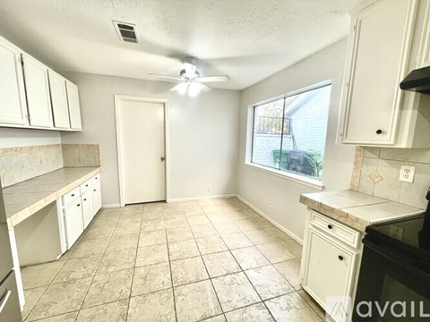 A kitchen with white cabinets and a black stove top oven.