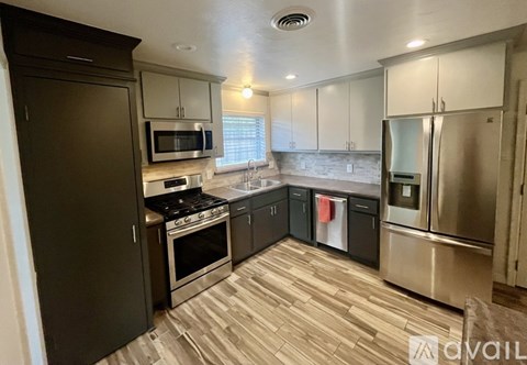 A kitchen with dark brown cabinets and stainless steel appliances.