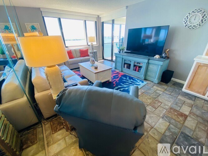 A living room with a grey couch and a television on a cabinet.