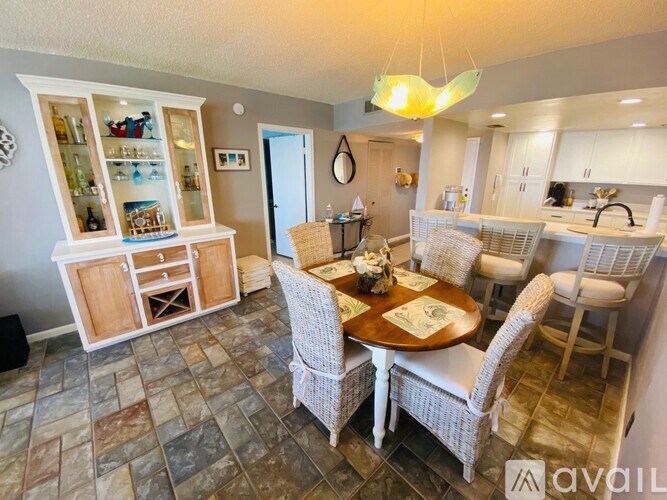 A dining area with a table set for four and a bar area with glasses on the counter.