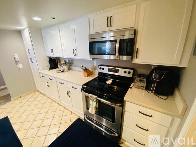 A kitchen with white cabinets and a black stove top.