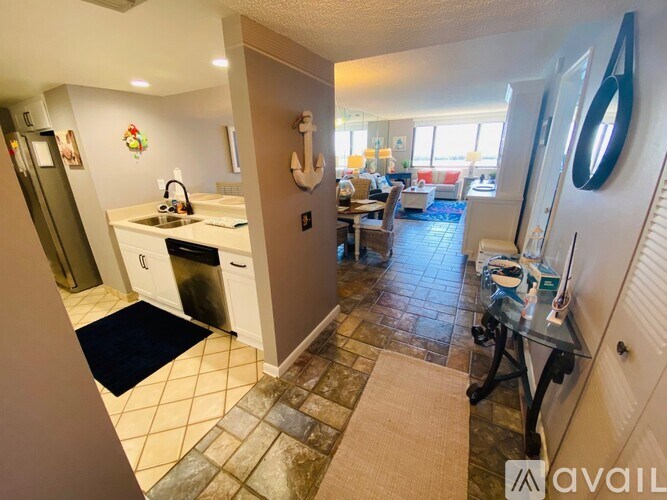 A kitchen with a black mat on the floor.