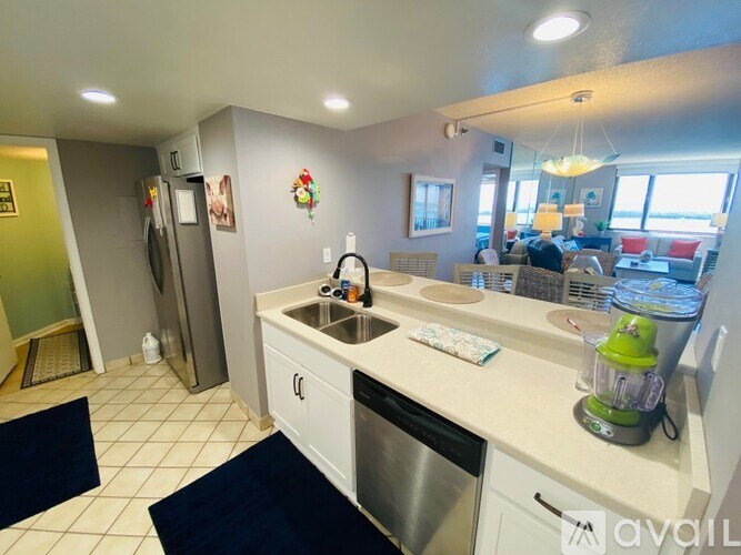 A kitchen with white cabinets and a green blender on the counter.
